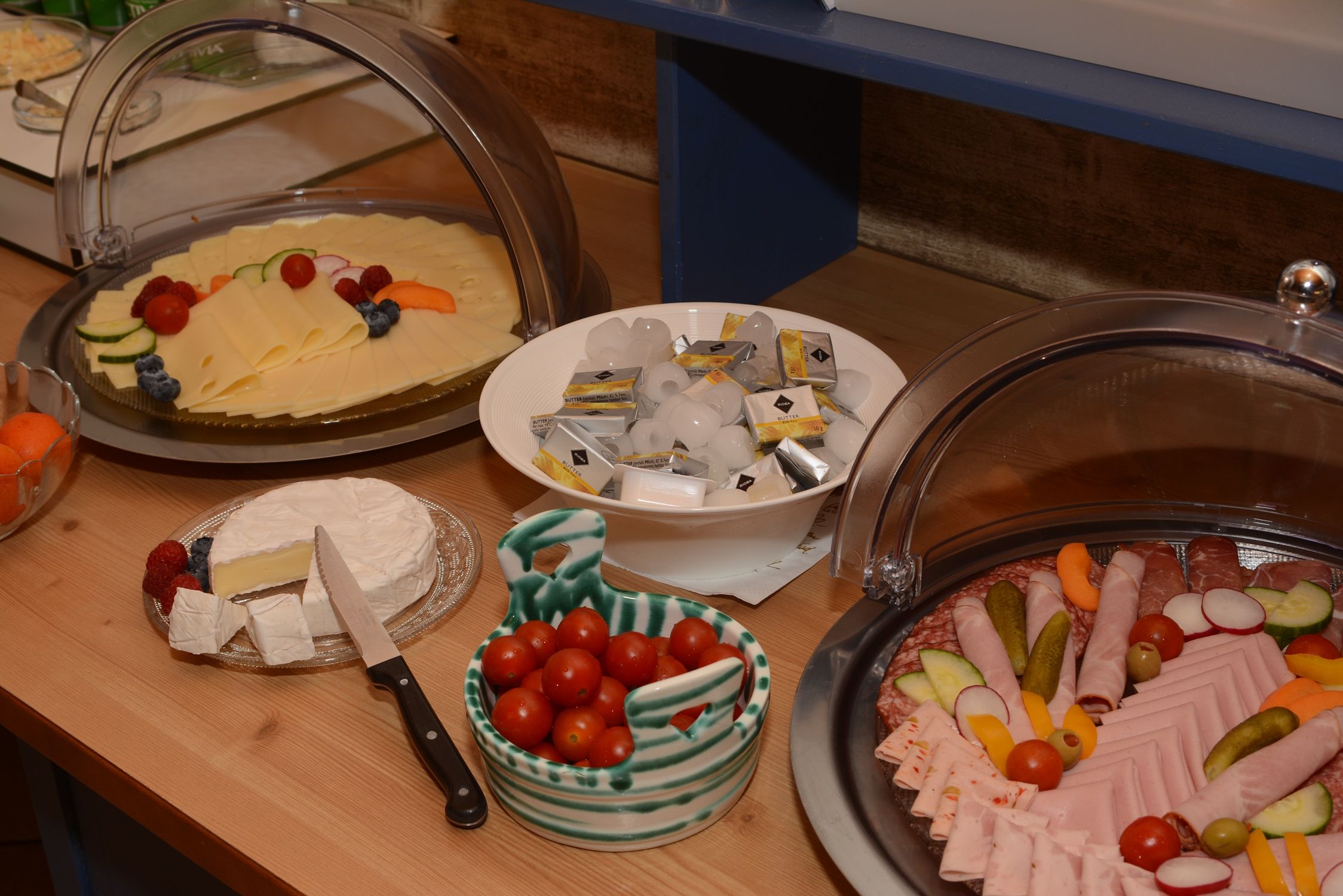 Reggeli büfé sajtokkal, kolbásszal, paradicsommal, vajjal és camambert-tel.