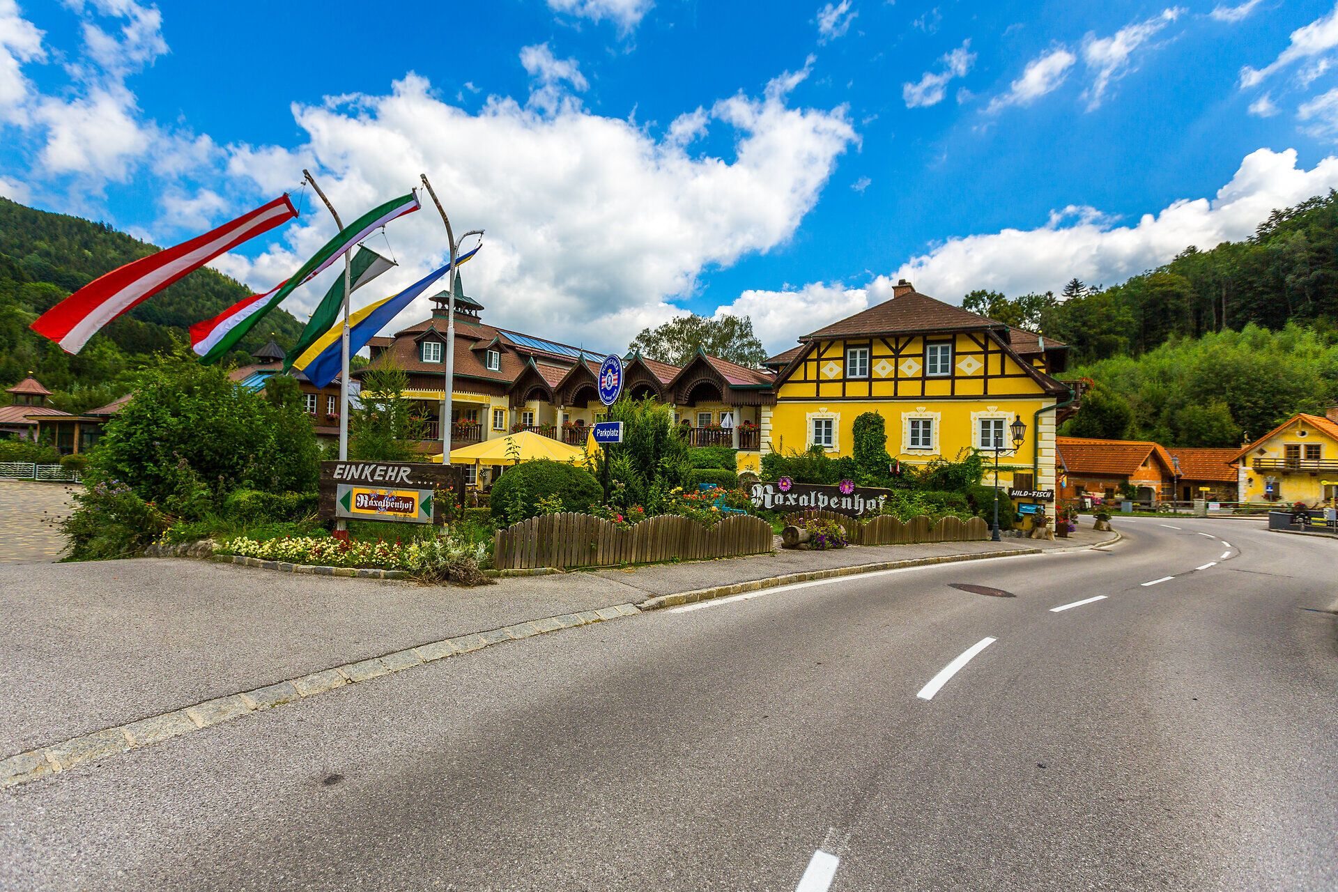 A Raxalpenhof közvetlenül a helyi úton található, a ház előtt egy kék szökőkút van, virágok és bokrok sorakoznak az erkélyeken és a ház teljes elülső részén.