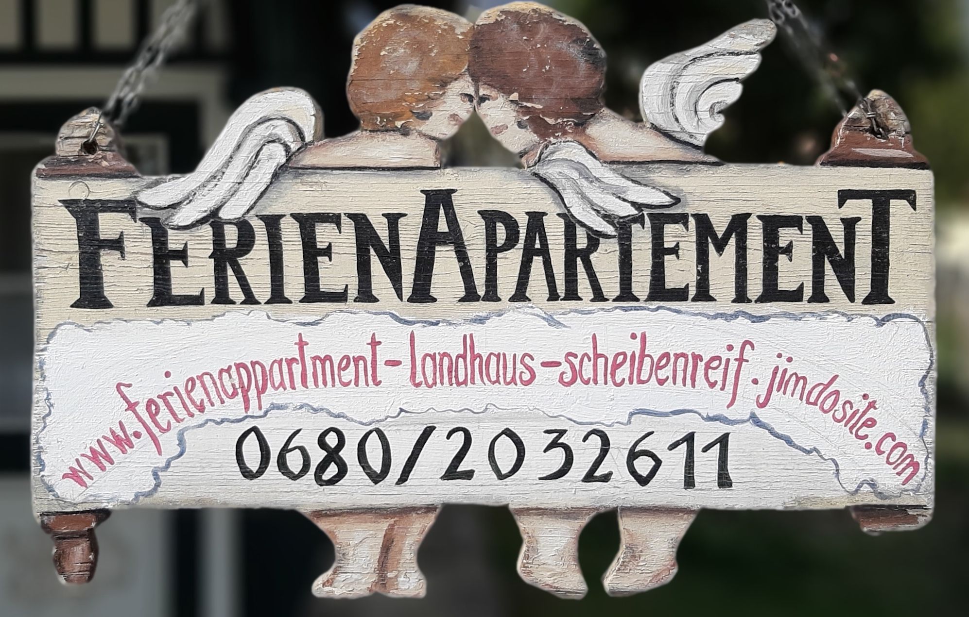 Fából készült tábla "Holiday apartment" felirattal és két angyallal.