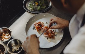 A szakács elkészíti az ételt a tányéron.