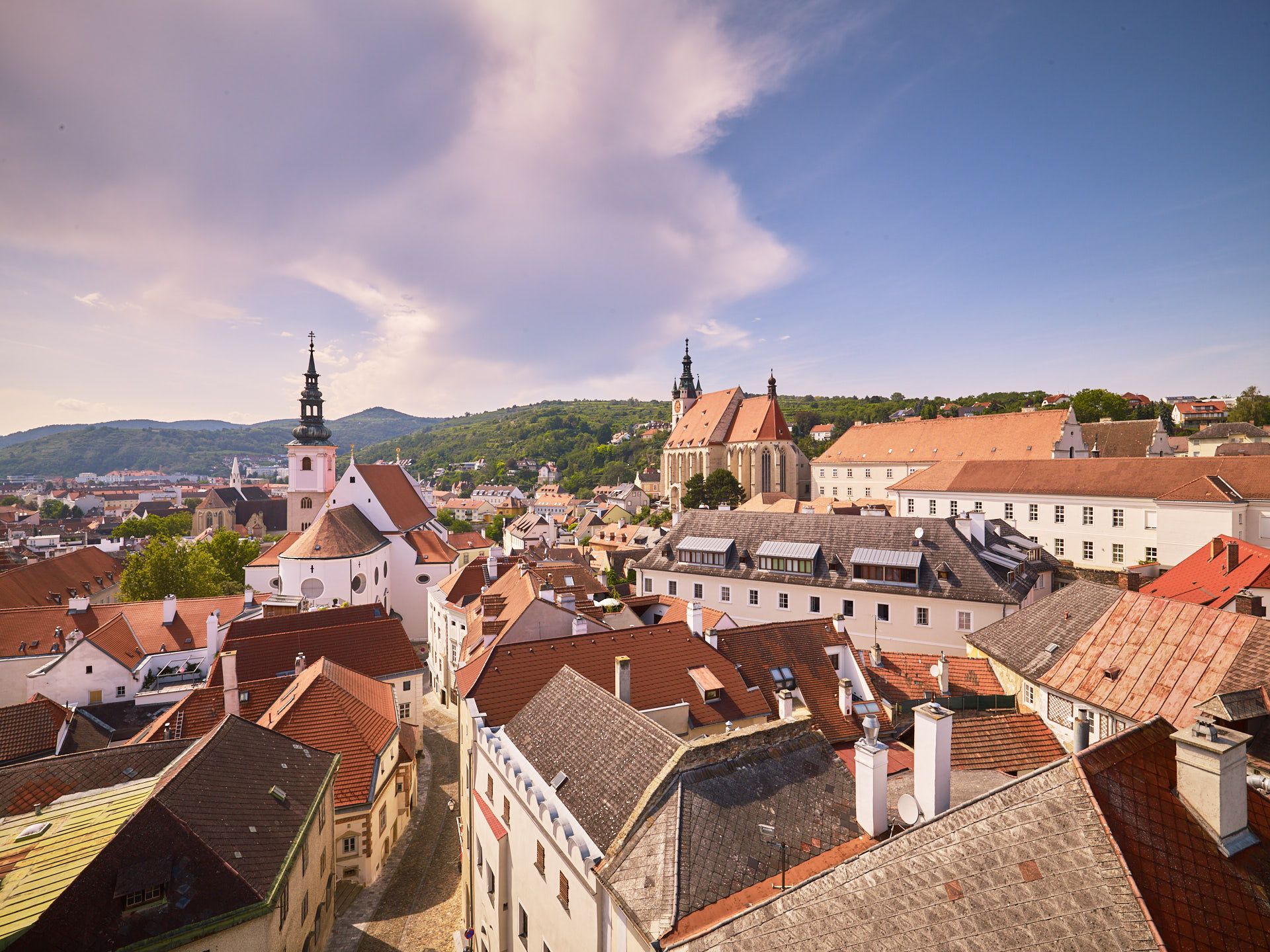 Krems régi városközpontjának panorámája a templomokkal és a vörös tetőkkel.