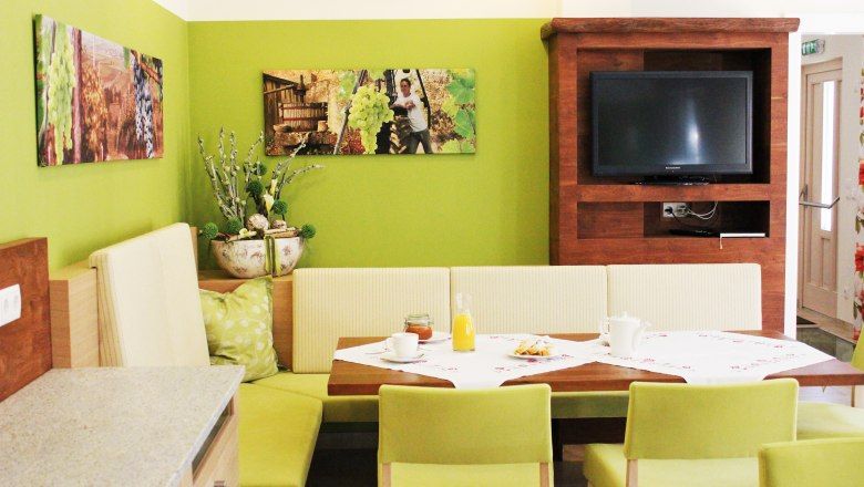 Hangulatos étkező zöld falakkal, fabútorokkal és TV-vel.