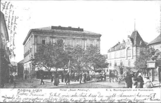 A Hotel Stadt Mödling történelmi látképe, emberek és kocsik az utcán.