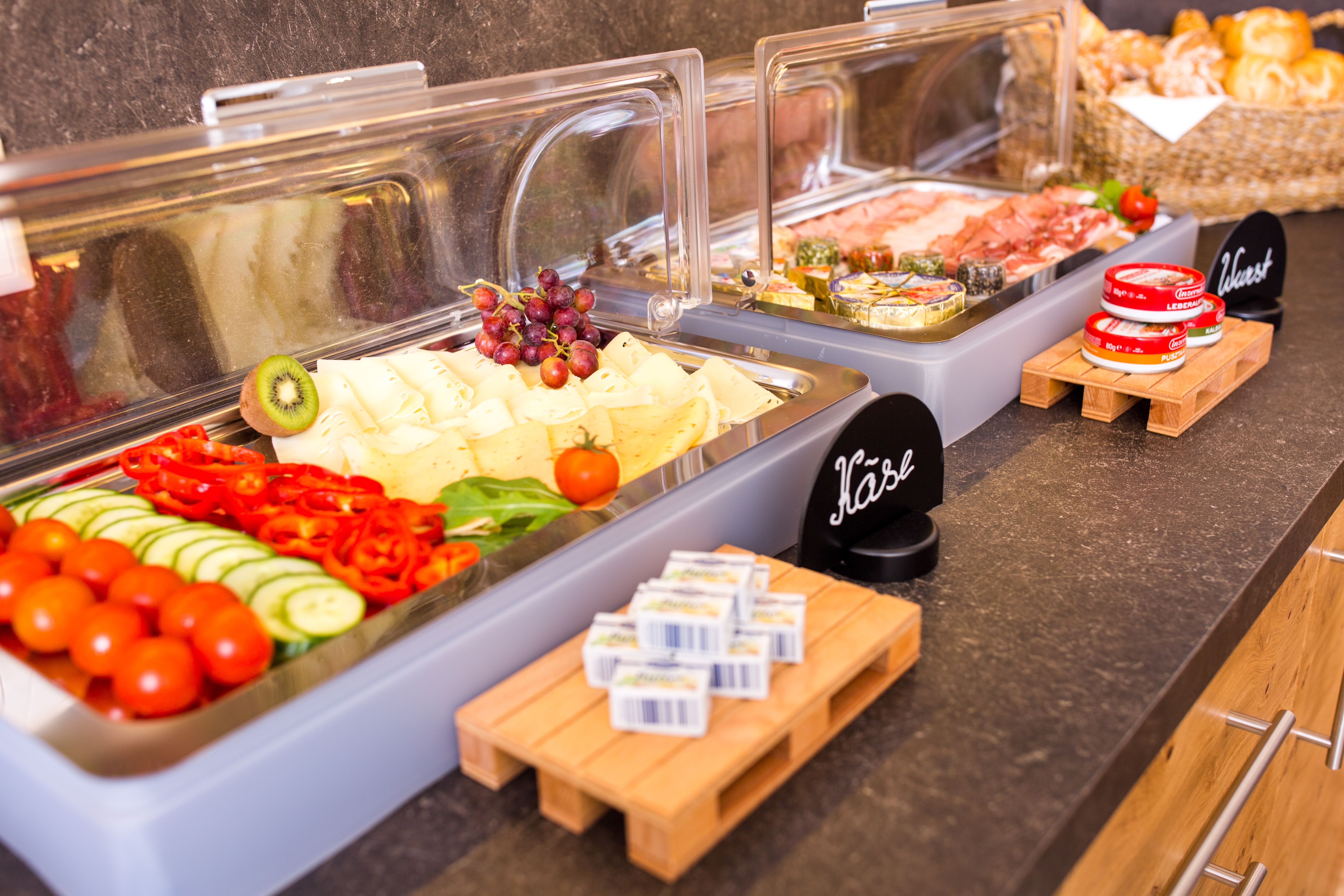 Büfé sajtokkal, felvágottakkal, zöldségekkel és kenyérrel.