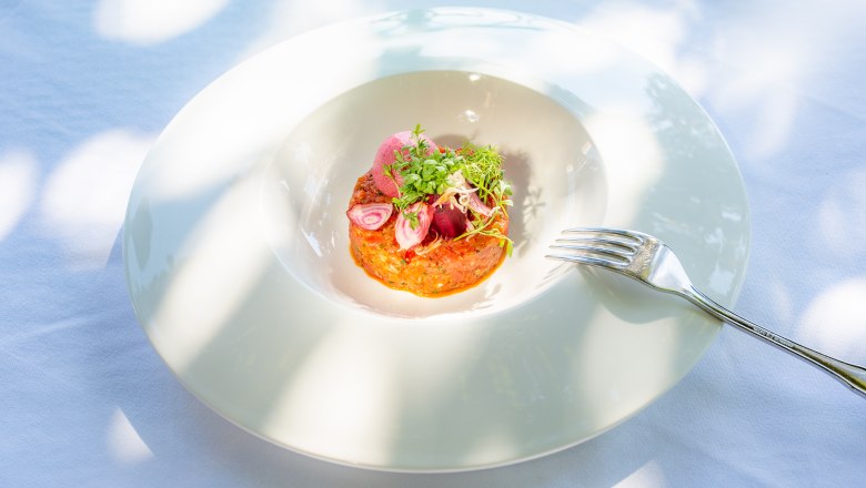 Egy feh&eacute;r t&aacute;ny&eacute;ron műv&eacute;szien elrendezett t&aacute;ny&eacute;r, mellette egy villa.