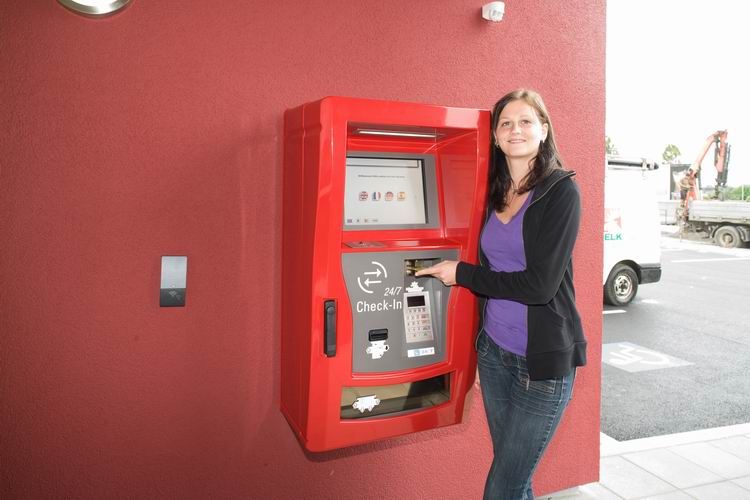 Egy nő használja a bejelentkezési automatát a Cleverhotel Herzogenburgban.