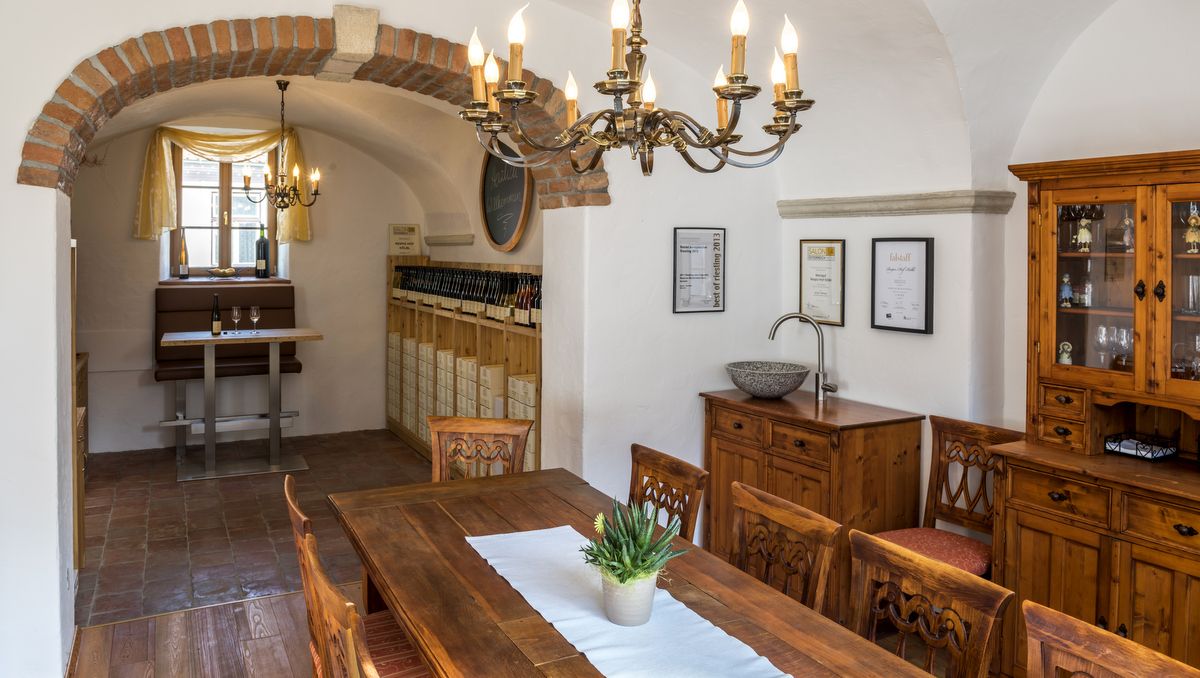 Hangulatos szoba fabútorokkal, csillárral és bortartóval.