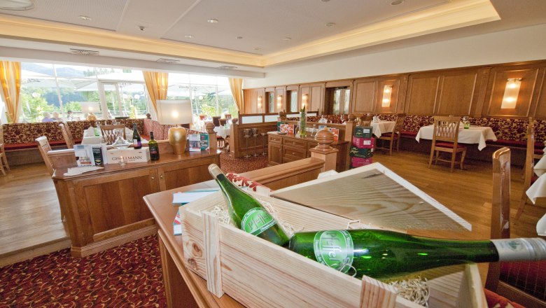 Egy eleg&aacute;ns &eacute;tterem belső n&eacute;zete f&aacute;b&oacute;l k&eacute;sz&uuml;lt b&uacute;torokkal &eacute;s boros&uuml;vegekkel.