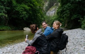 drei Wander:innen sitzen am Fluss im Höllental, © NÖW_Robin Uthe