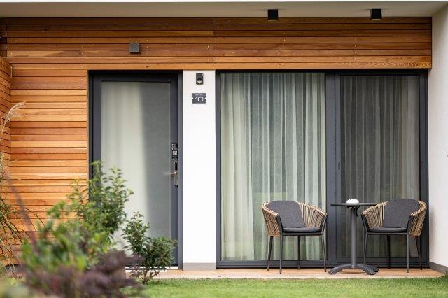 Modern terasz két székkel és asztallal egy vendégház előtt.