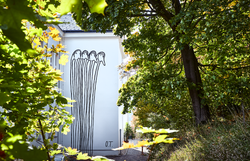 Inmitten der üppigen Natur des Wienerwaldes erhebt sich eine faszinierende Wandmalerei, die die Fantasie anregt. Die stilisierten Figuren scheinen in einem harmonischen Dialog mit der Umgebung zu stehen und laden dazu ein, die kreative Energie des Ortes zu spüren. Ein Besuch hier verspricht nicht nur visuelle, sondern auch emotionale Erlebnisse.