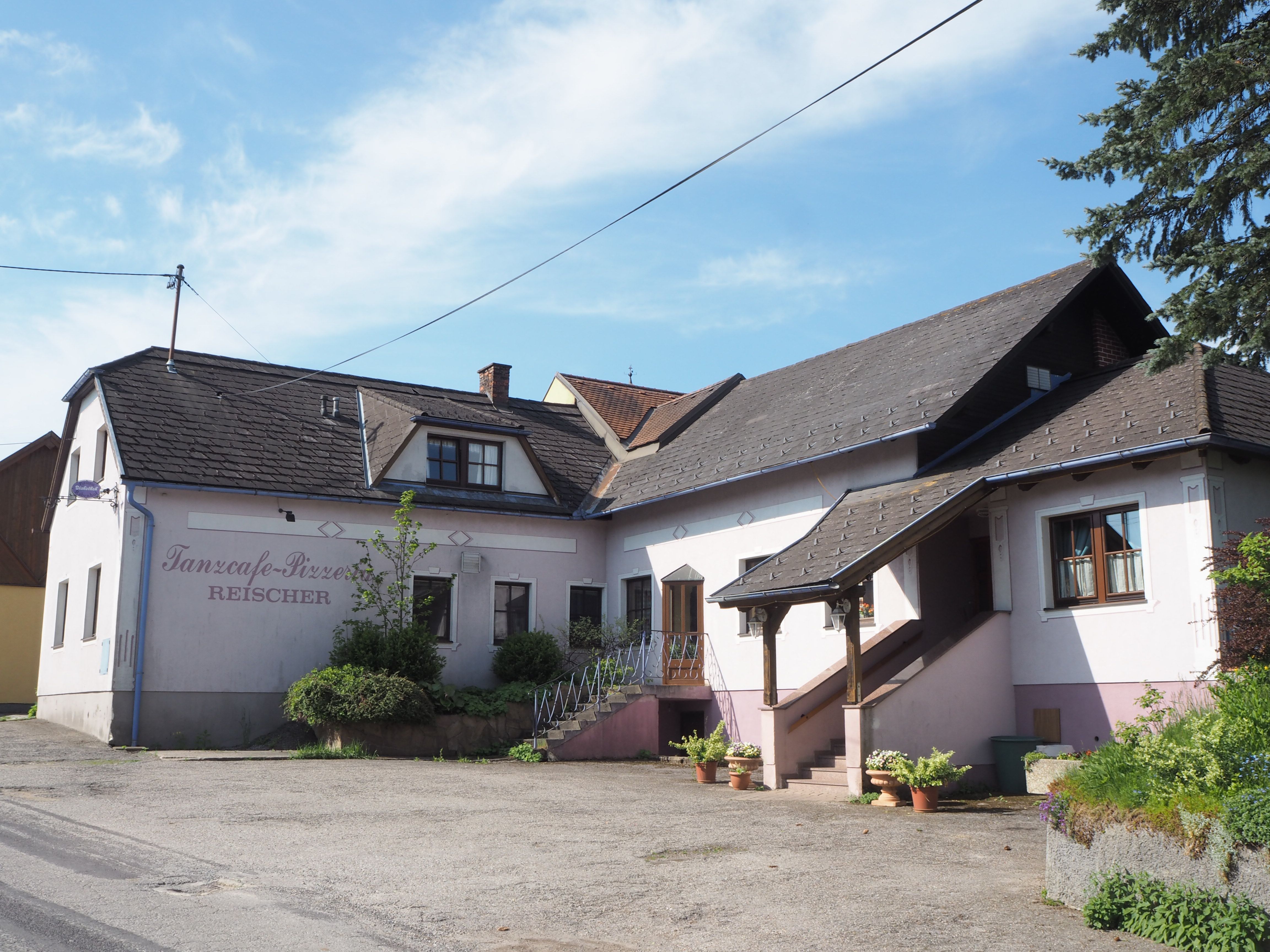 A "Tanzcafe-Pizzeria Reischer" feliratú épület külső nézete.