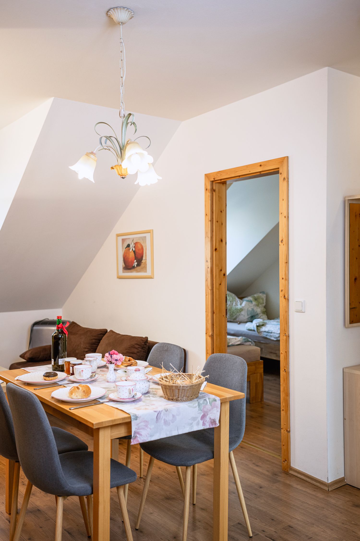 Étkező egy lakásban terített asztallal és kilátással a hálószobába.