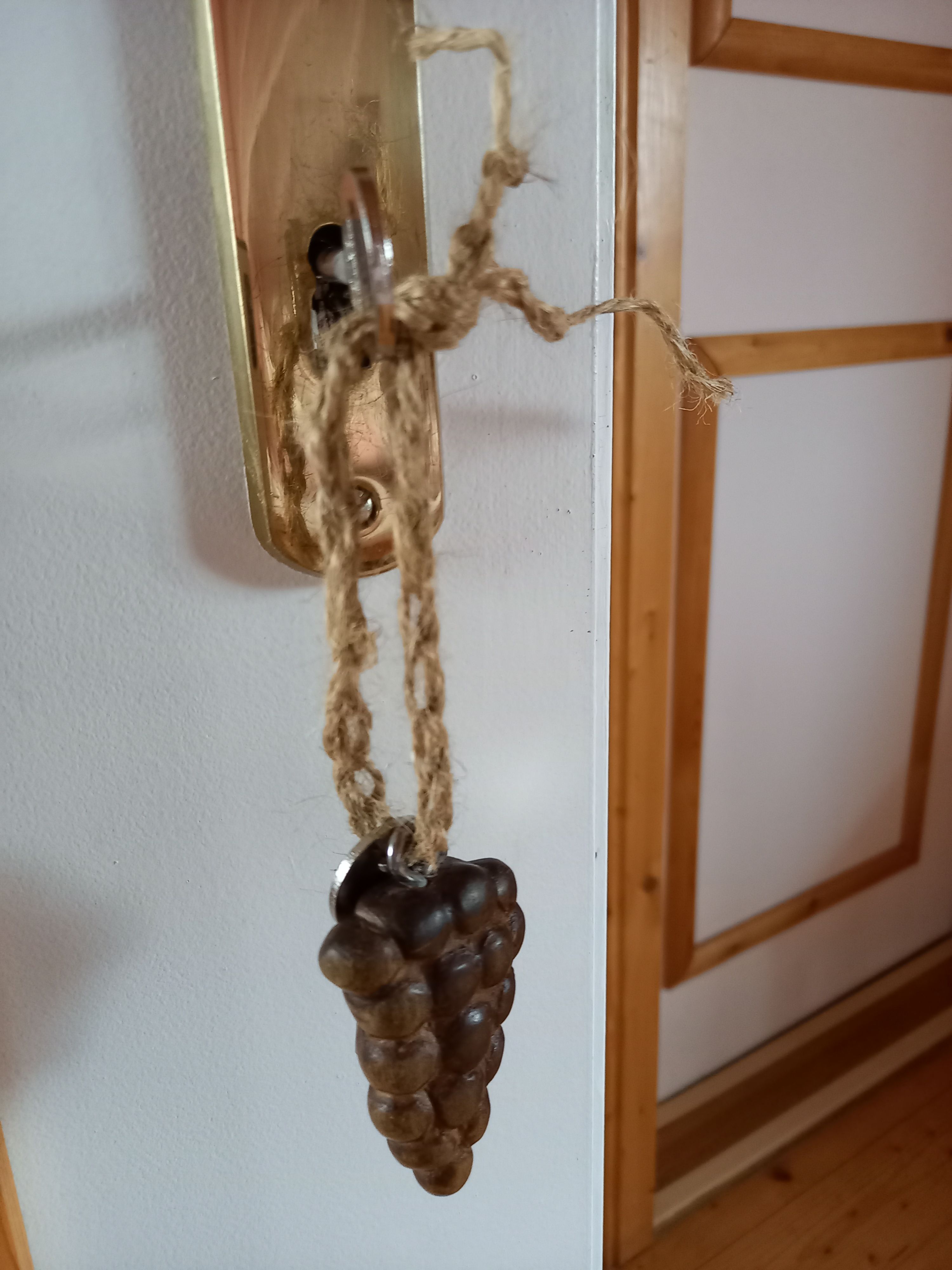 Ajtókilincs fából készült szőlő medállal.