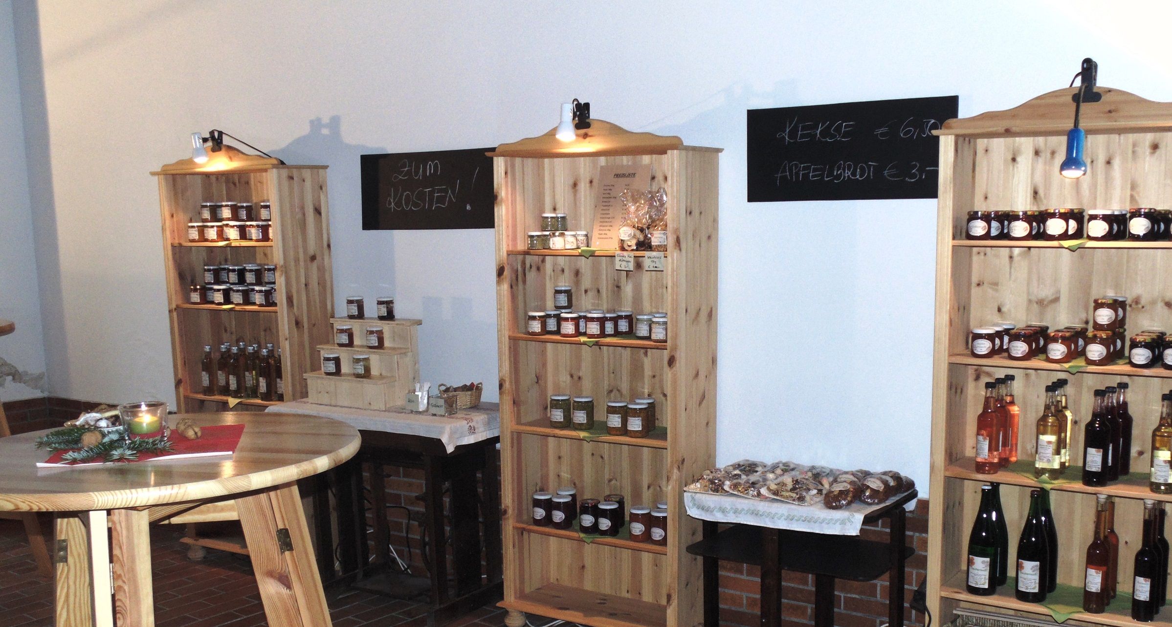 Egy mezőgazdasági bolt belső nézete, tele polcokkal, lekvárokkal, gyümölcslevekkel és kekszekkel.