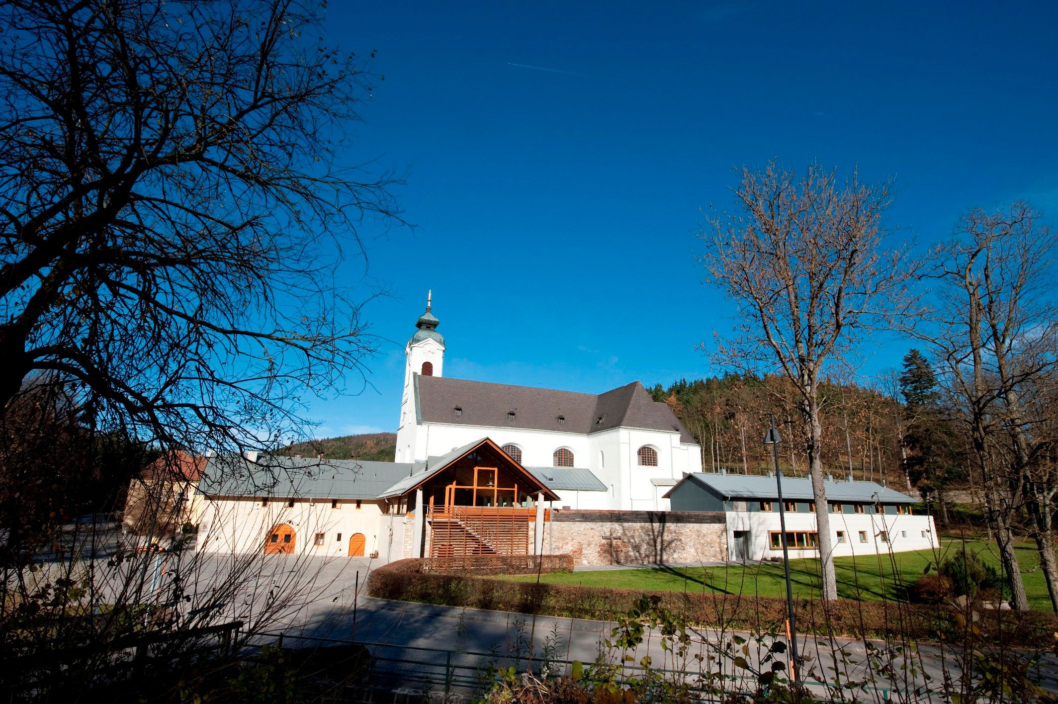 Zarándoktemplom Klein-Mariazell kék éggel és fákkal az előtérben.