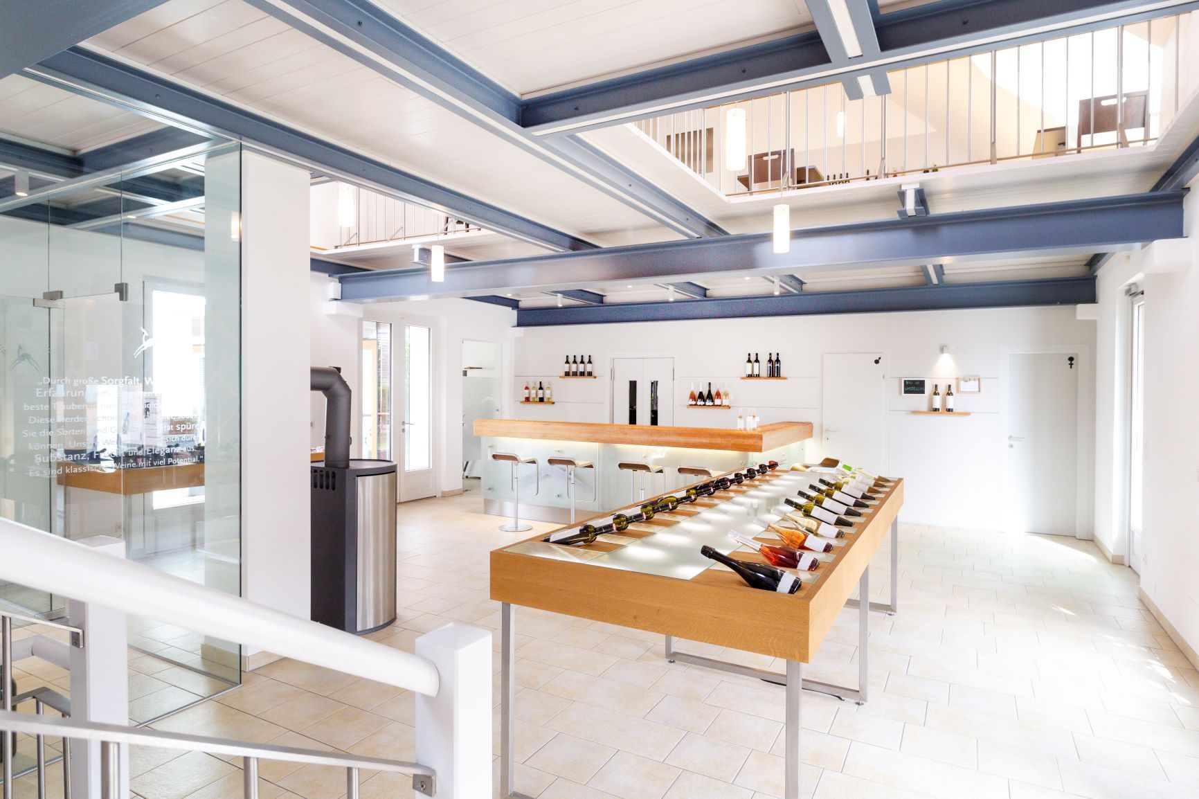 Egy modern borbár belső nézete, borosüvegekkel az asztalon és egy bárpult a háttérben.