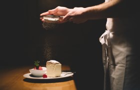 Egy tányér krémszelet és málnaszörbet, porcukorral megszórva.