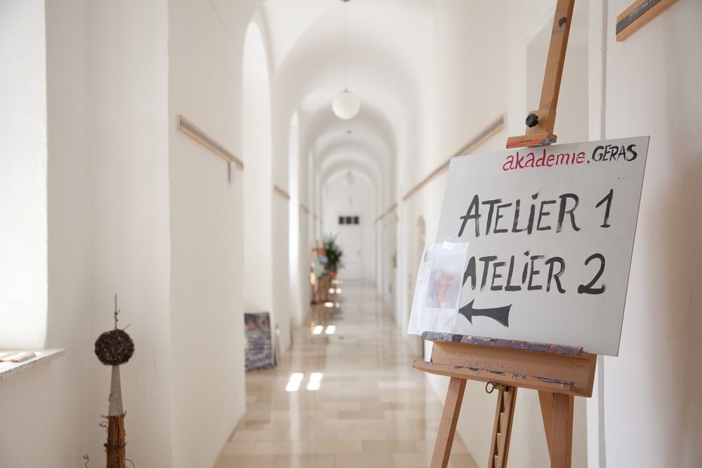 Egy világos folyosó, egy tábla egy állványon, amely az Atelier 1 és a Atelier 2 felé mutat.
