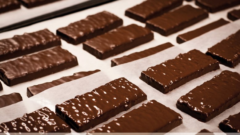 Csokol&aacute;d&eacute;val bevont kekszek s&uuml;tőpap&iacute;ron a cukr&aacute;szd&aacute;ban.