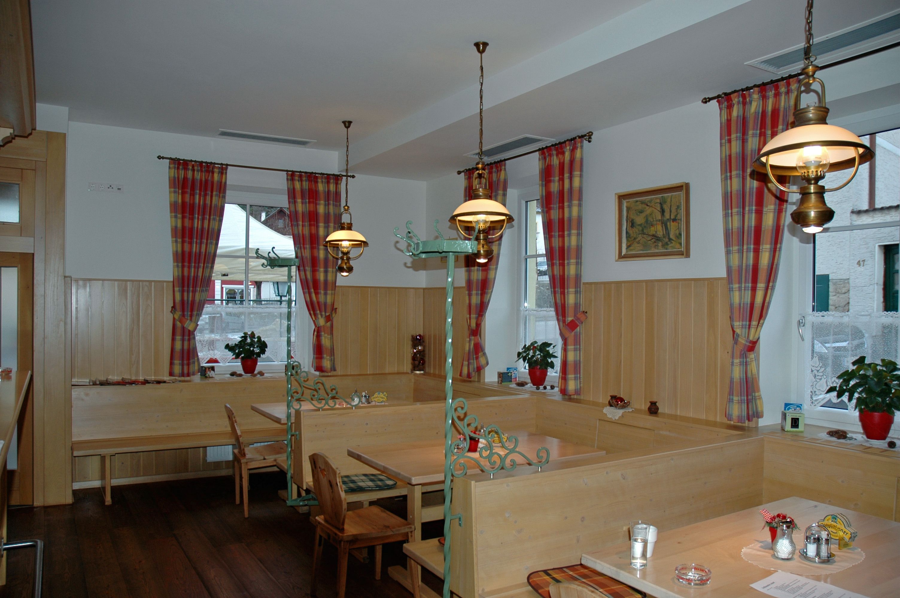 Hangulatos étkező fabútorokkal és kockás függönyökkel.