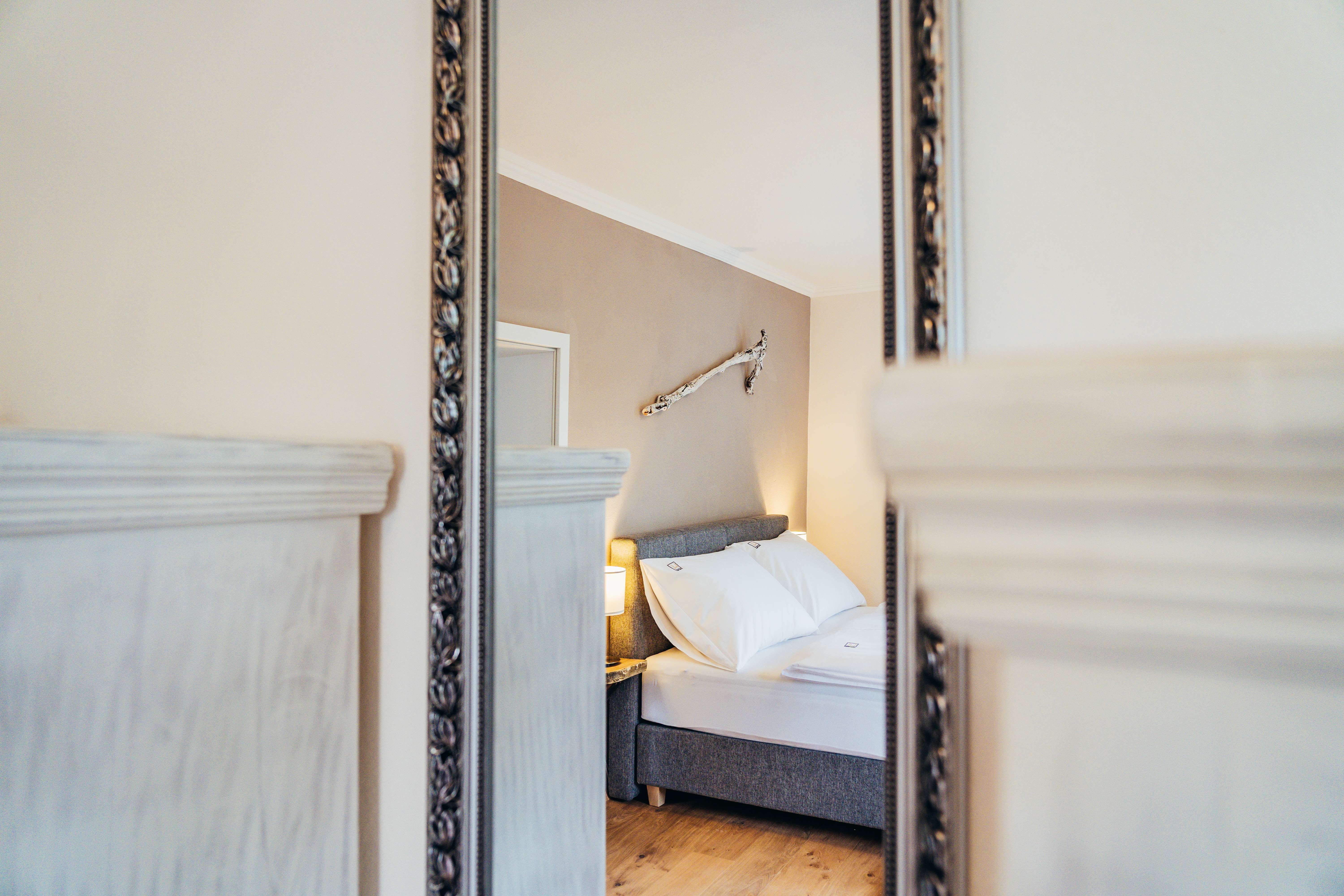 Egy hangulatos hálószoba tükörképe, ágy és fali dekoráció.