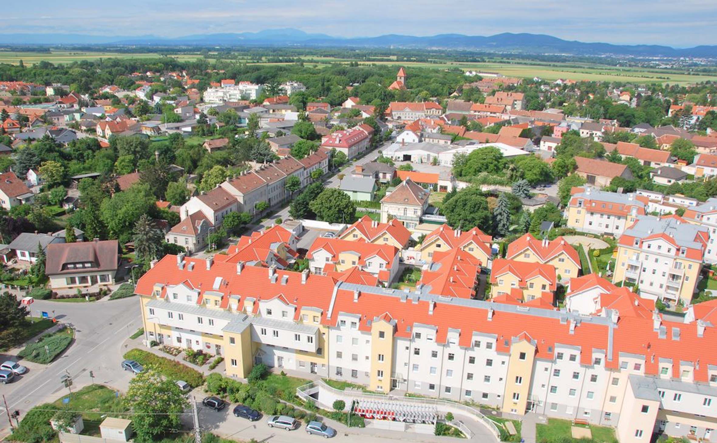 Légi felvétel Himbergről, piros tetőkkel és zöld tájjal.