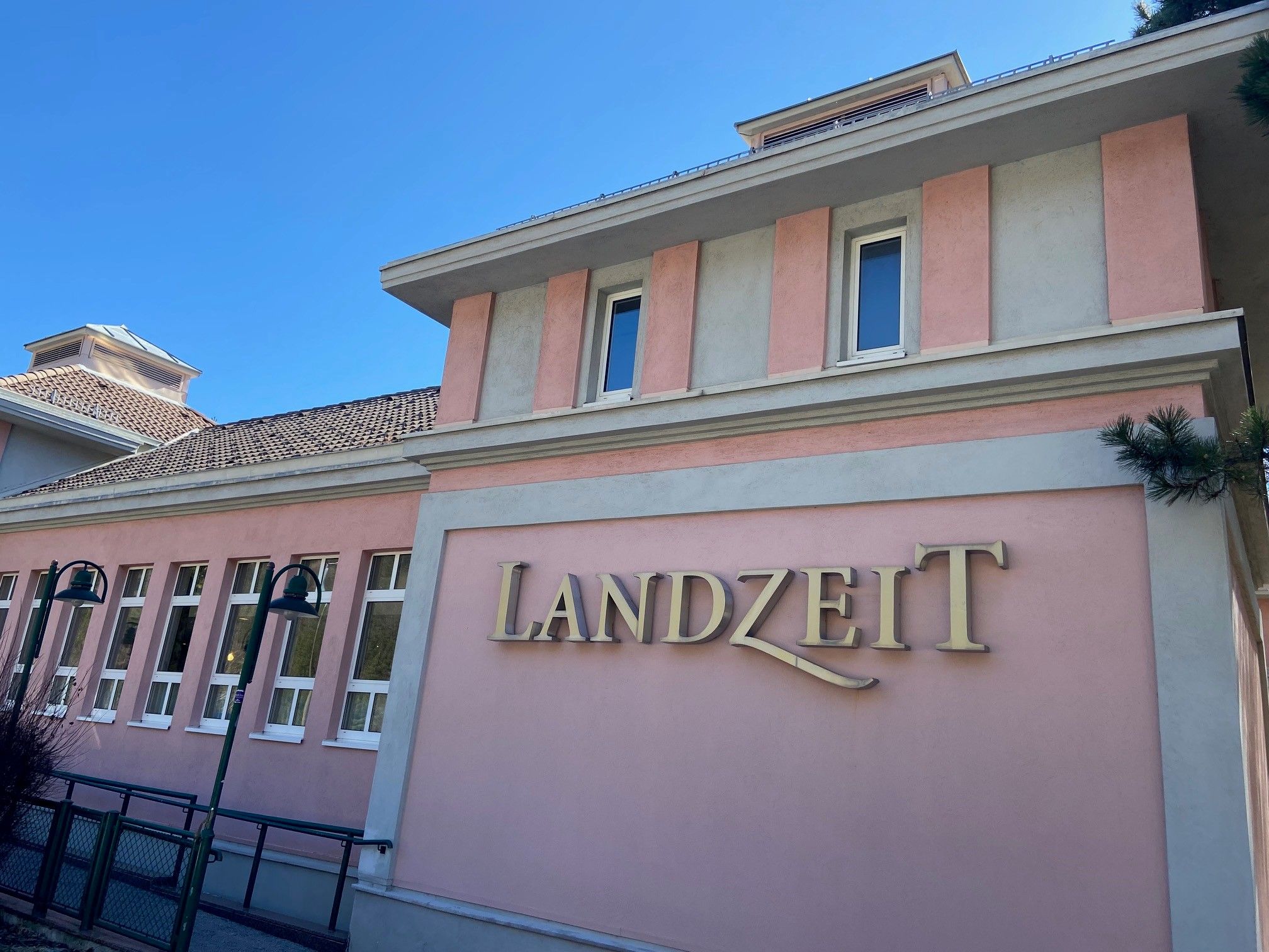 Rózsaszín homlokzatú épület "Landzeit" felirattal.