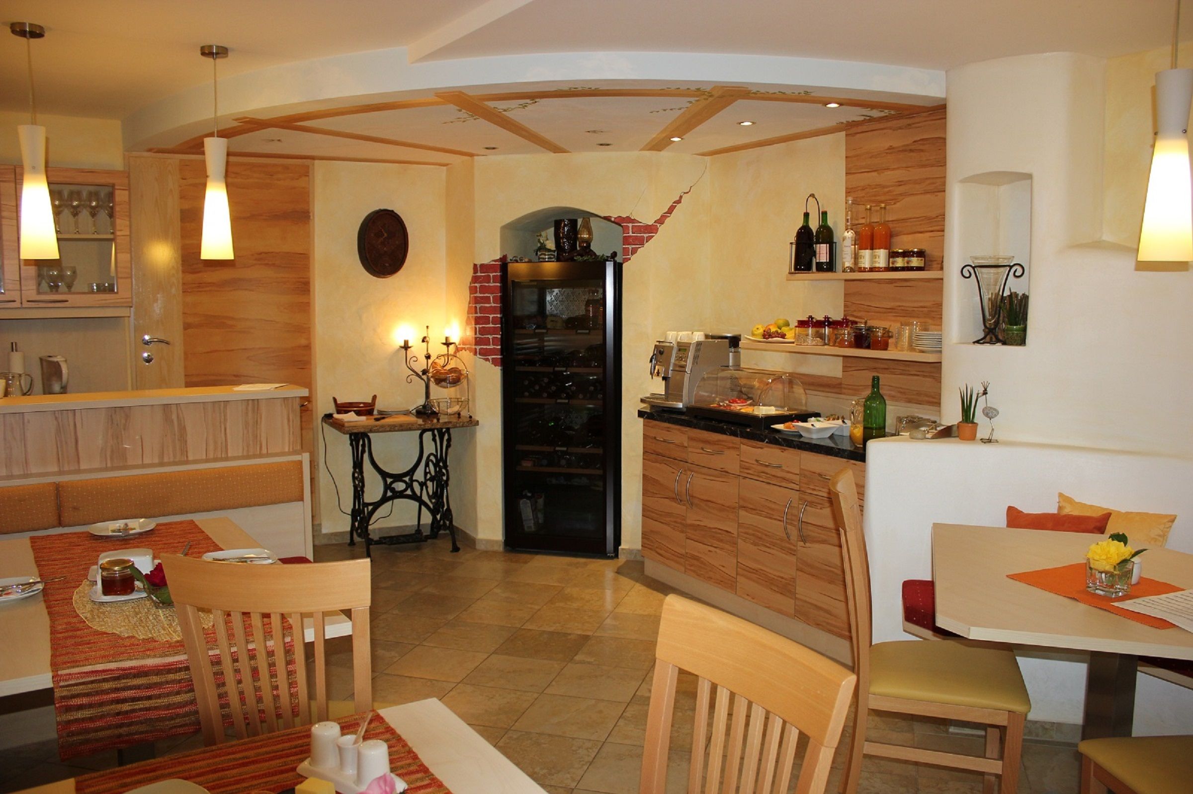 Hangulatos reggelizőterem fabútorokkal, terített asztalokkal, valamint büféasztal italokkal és ételekkel.