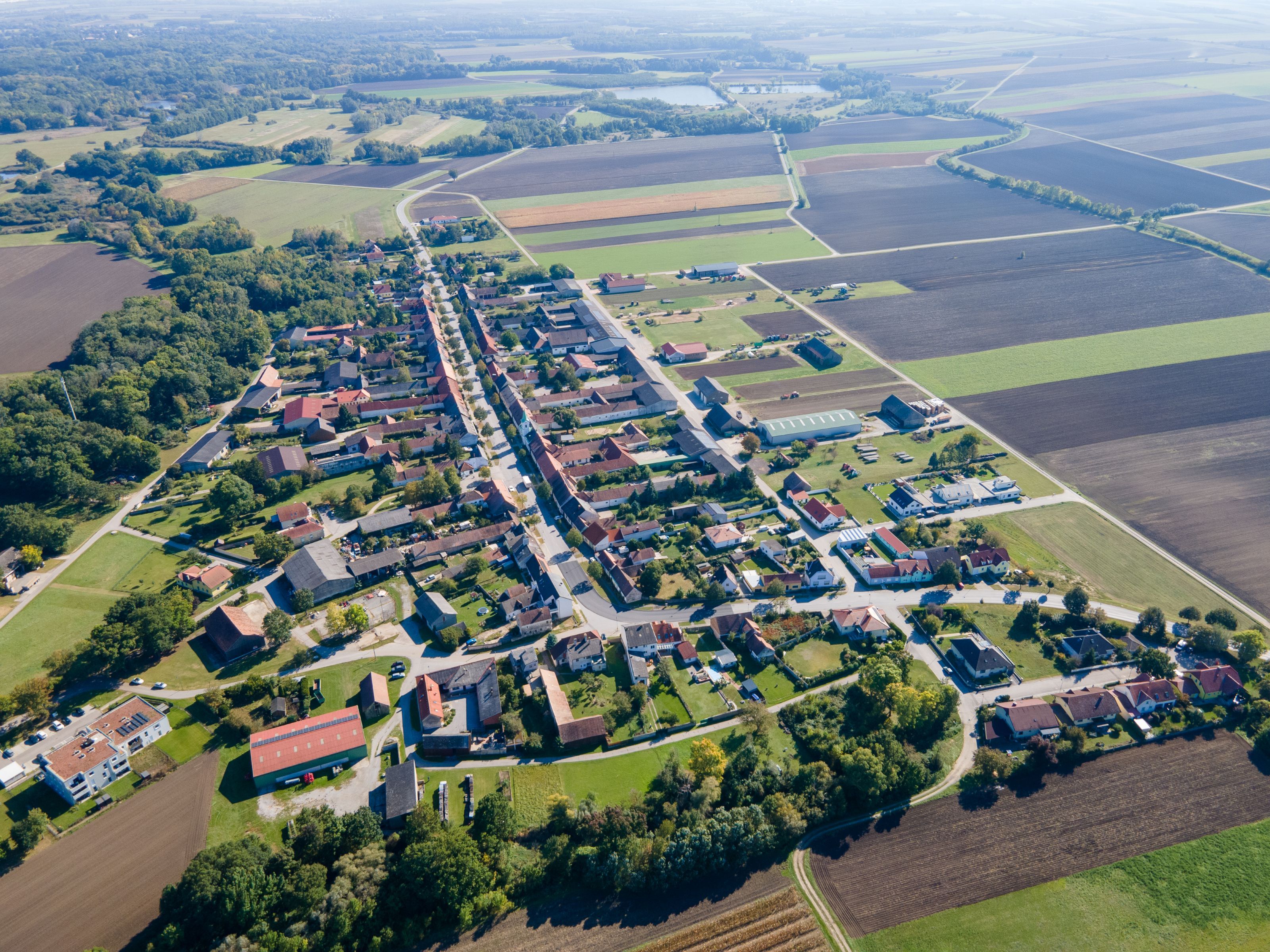 Weiden an der March település légi felvétele a falu központjával, a környező mezőkkel és erdősávokkal.