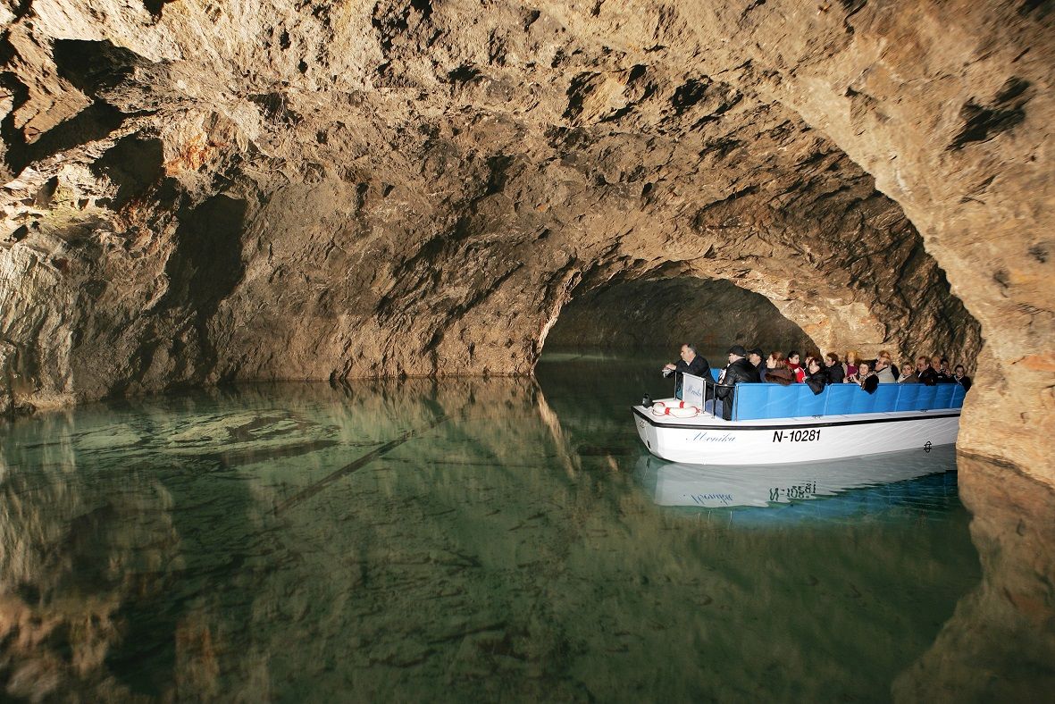 Csónaktúra egy földalatti barlangban turistákkal egy kis csónakon.